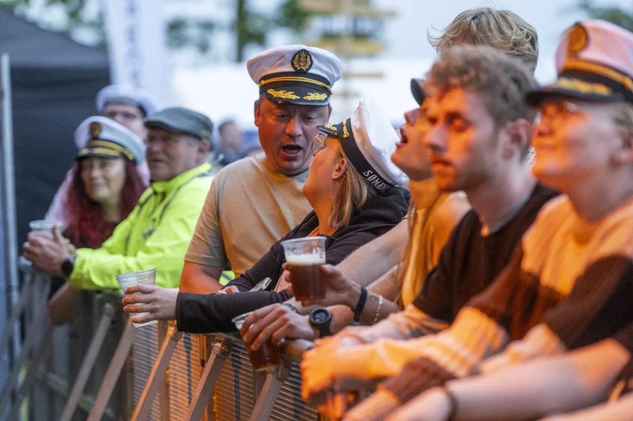 Publikum i kaptajnshuer helt oppe ved hegnet