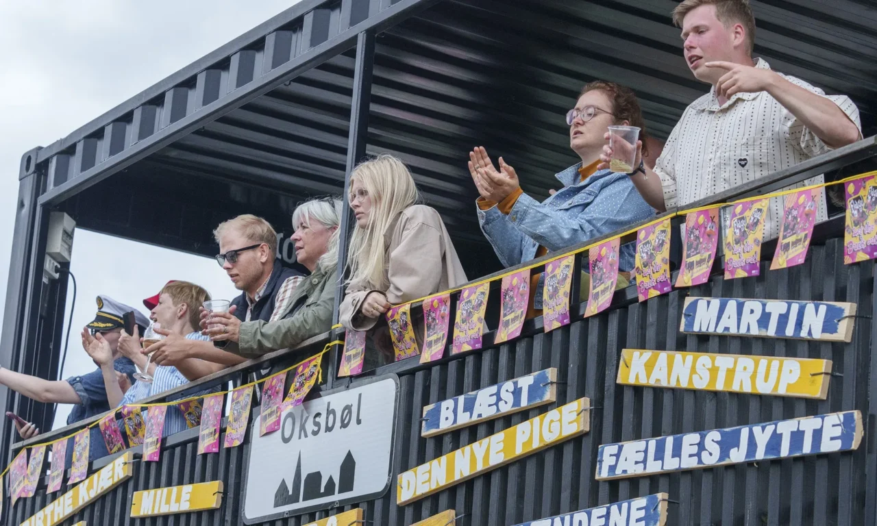 Gæster på en container pyntet med bannere