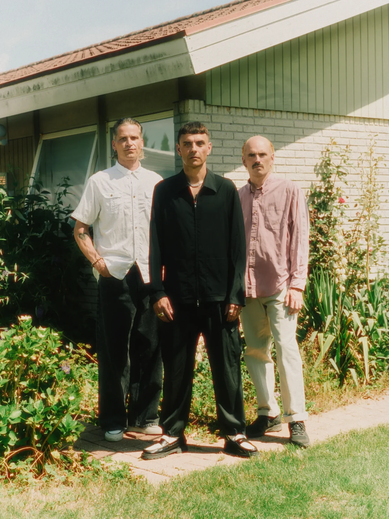 HUGORM. Simon Kvamm, Morten Gorm og Arni Bergmann foran et hus i solskin